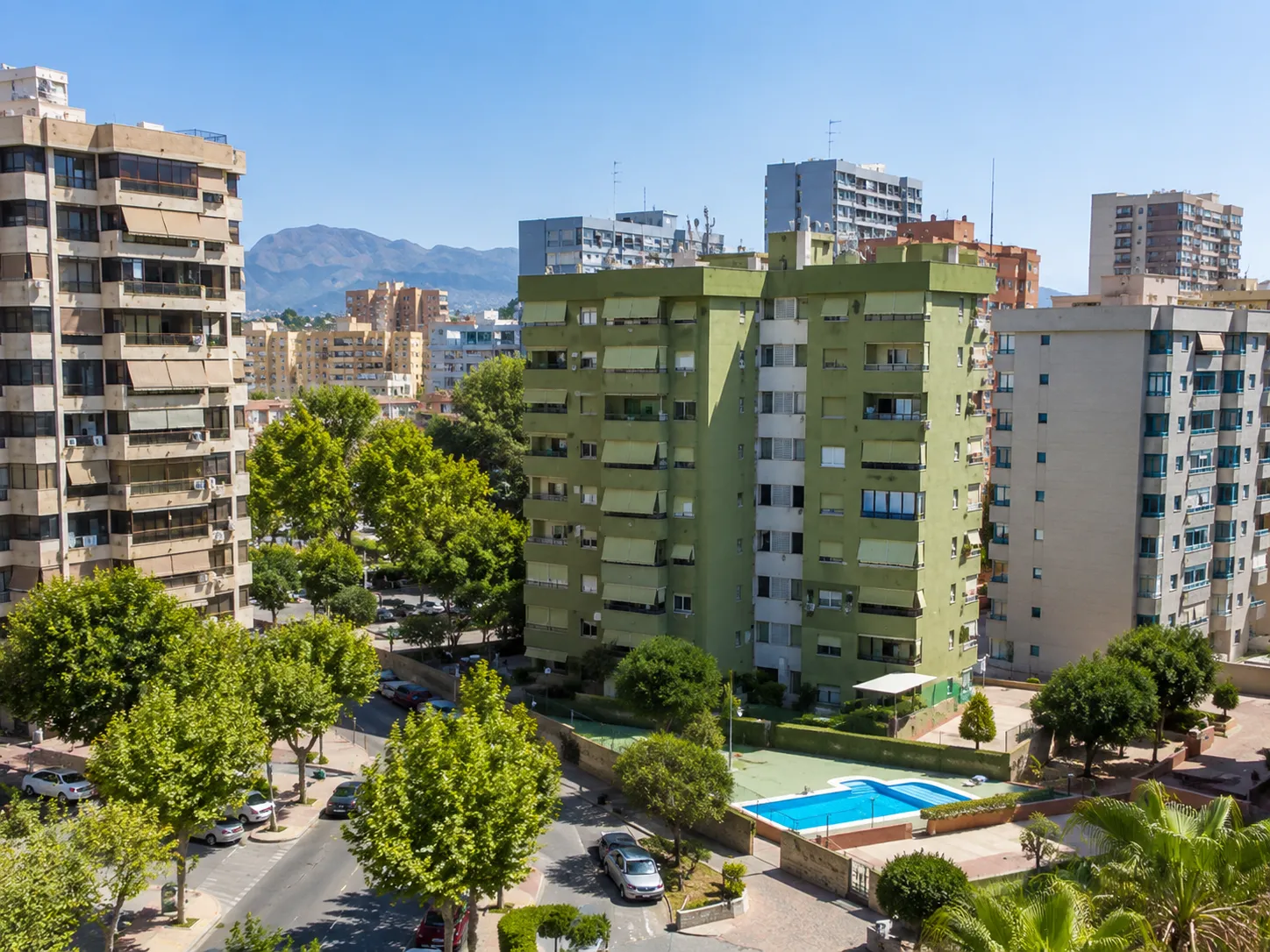 Vista elevada de un edificio residencial en Els Tolls, Benidorm, con piscina comunitaria y zonas ajardinadas